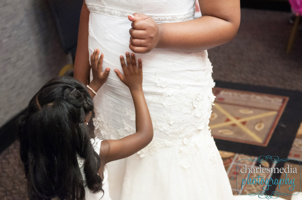 flower girl touching bride's stomach
