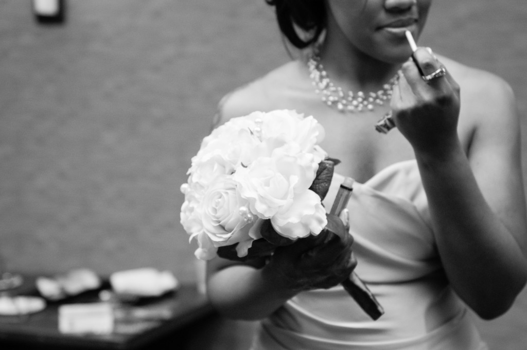 bridesmaid holding bouquet, applying makeup