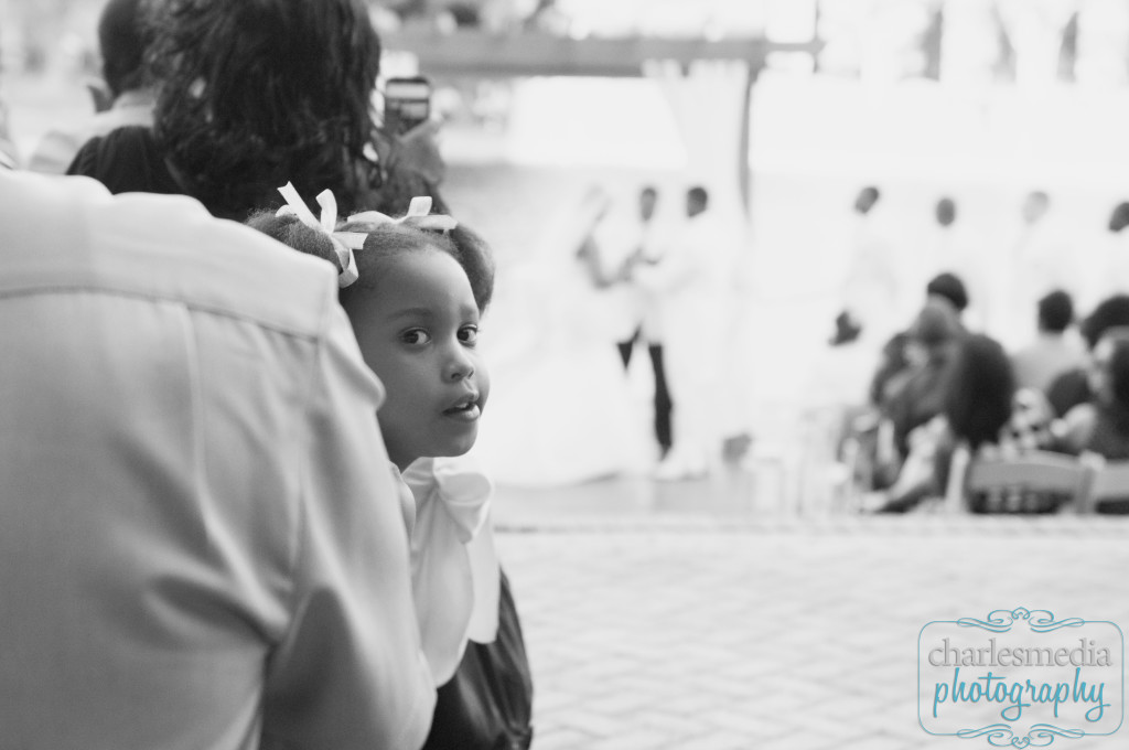 Child guest at wedding with ceremony in the background